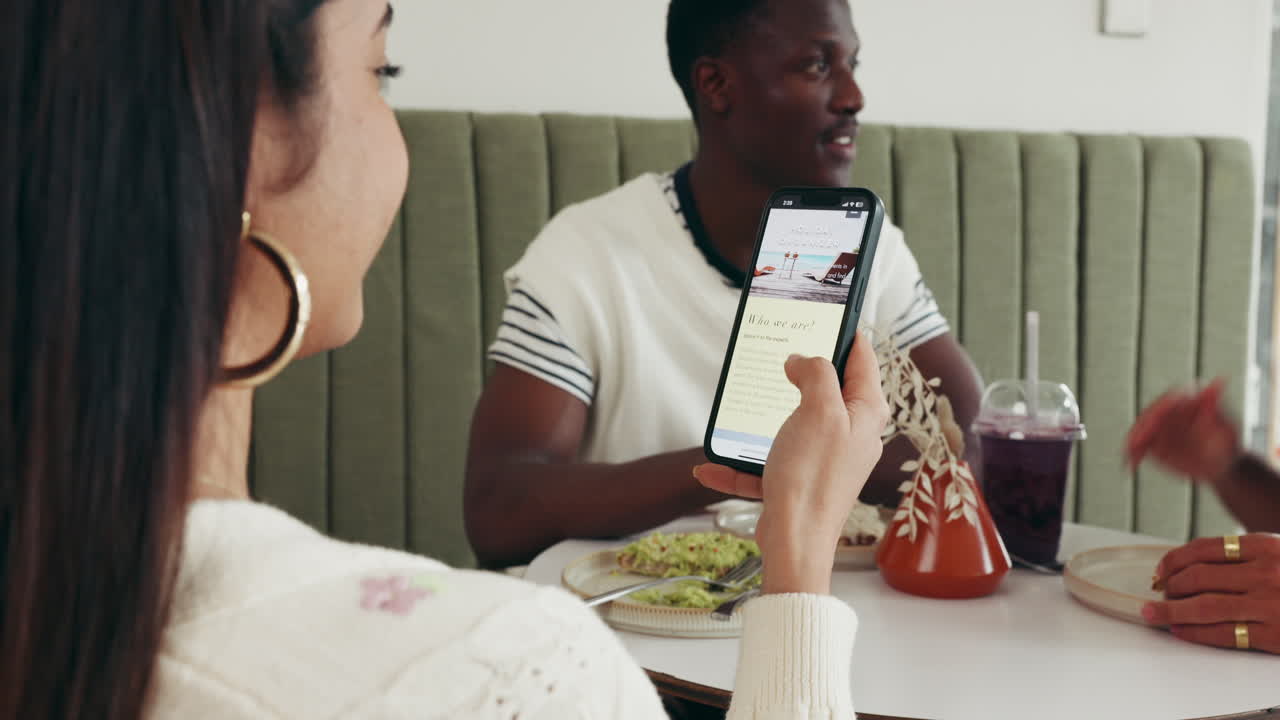 People at a restaurant using a phone