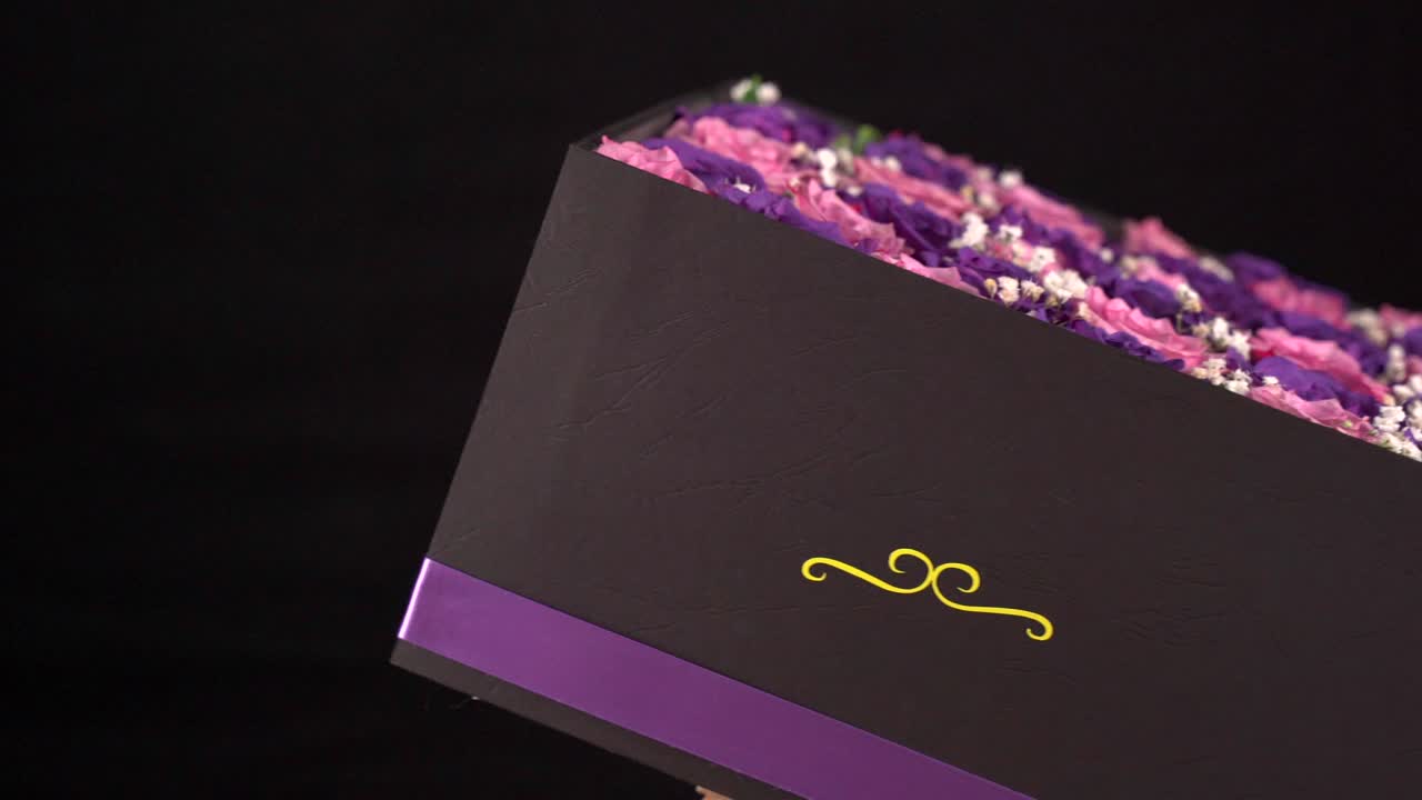 Gift present box of pink and purple roses spinning in black background Mi love Mi amor Spanish