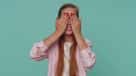 curious teenager young girl closing eyes with hand and spying through fingers, hiding and peeping