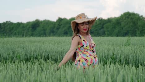 pregnant girl walking in a wheat field