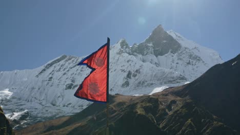 nepal country flag and mountains, nepalese flag and big snowcapped himalayas mountains with beautiful mountain scenery and massive snowy summits with flag blowing in the wind