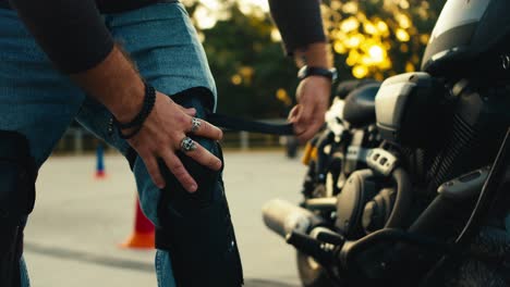 disparo en primer plano de un motociclista masculino poniendo grandes rodilleras. motocicletas y bicicletas de conducción segura