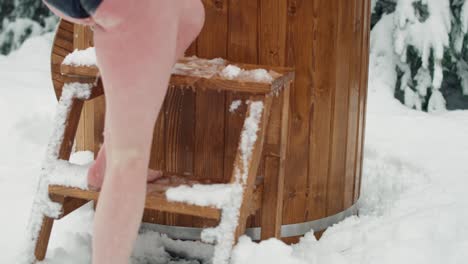 caucasian couple finished the frozen bath in wooden barrel.