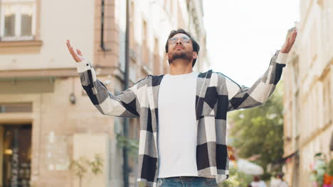 joven turista indio meditando respira profundamente con el gesto mudra mientras está de pie en la calle de la ciudad