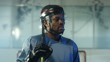 portrait of a happy male hockey player looking at the camera on the ice arena