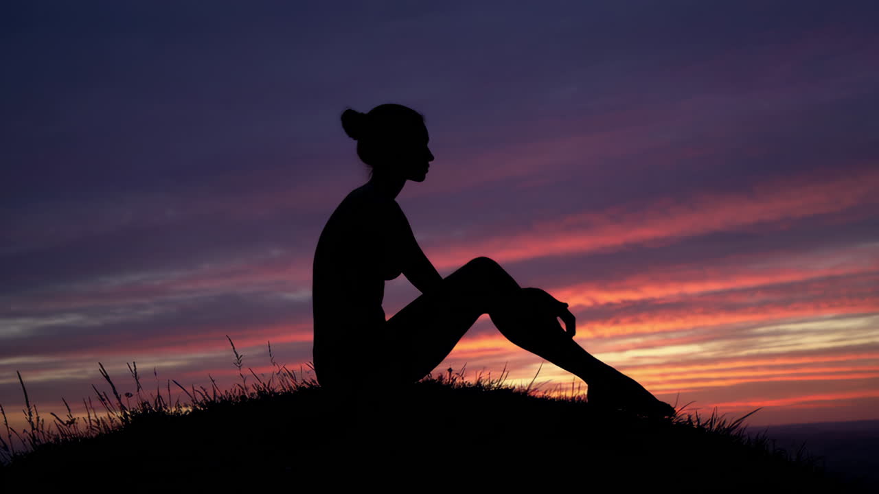 Silhouette of a Woman Sitting at Sunset