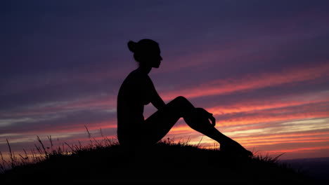 silhouette of a woman sitting at sunset