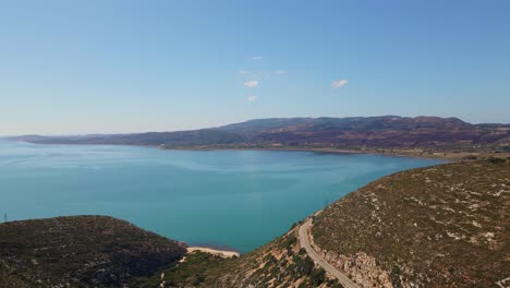 pull out over a road through the mountain landscape with ionian sea in the background