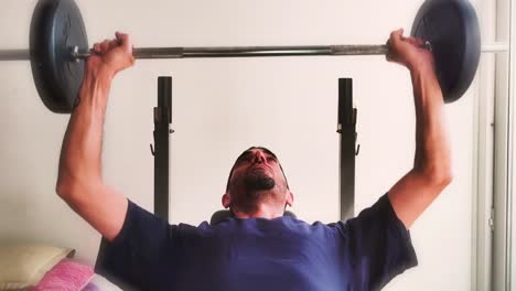 young man lifting weights at home