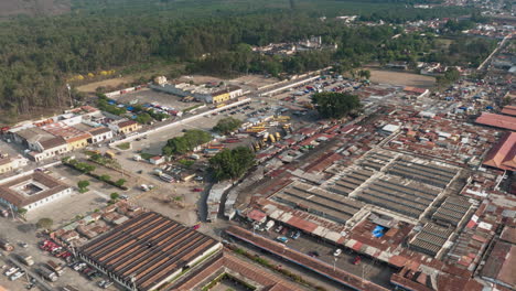 slow rotating aerial hyperlapse of chicken buses arriving and leaving at the market in antigua, guatemala