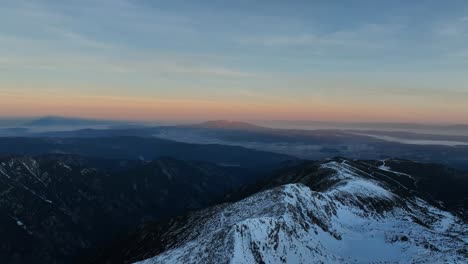 Disparo-De-Un-Dron-Desde-El-Pico-Musala-Durante-El-Amanecer,-A-Lo-Lejos-Se-Ve-La-Montaña-Vitosha-Y-La-Niebla-De-Sofia,-Bulgaria,-La-Cumbre-Más-Alta-De-Los-Balcanes,-La-Hora-Dorada,-La-Hora-Azul,-El-Amanecer