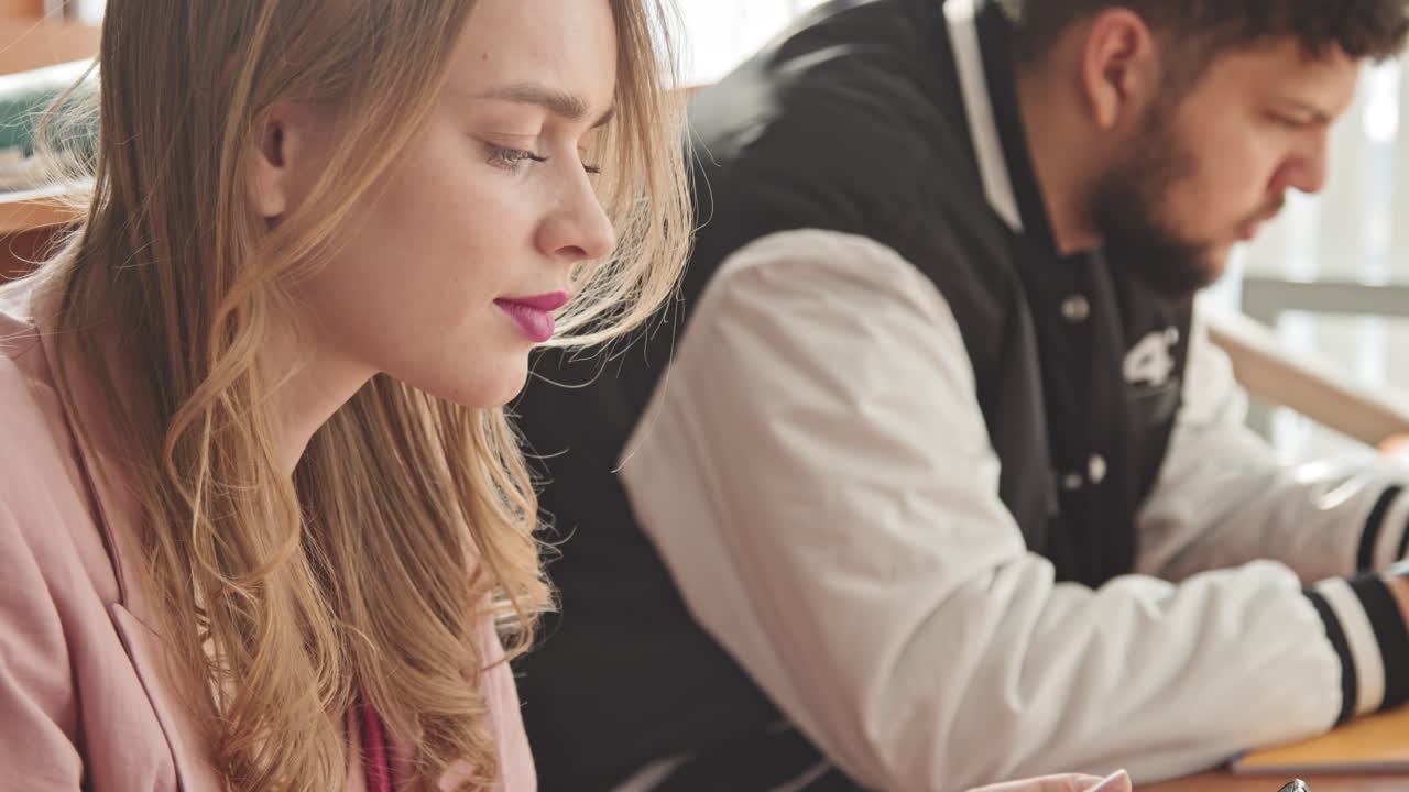 Female Student Scrolling through Smartphone in Class