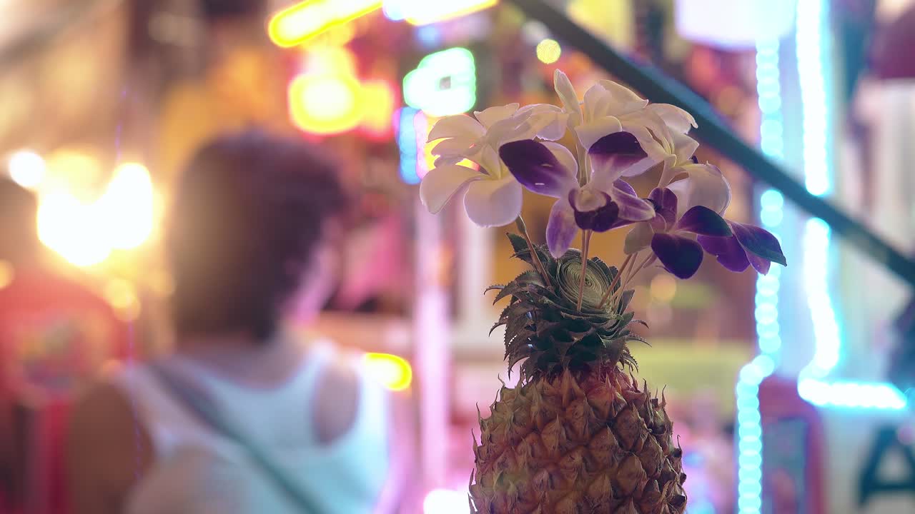 piña con orquídeas en fondo borroso con mujer