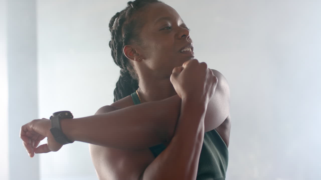 Stretching arms, strong fit woman in gym wearing fitness attire, preparing for workout