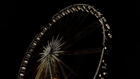 the large illuminated ferris wheel in budapest during nighttime - tilt up shot