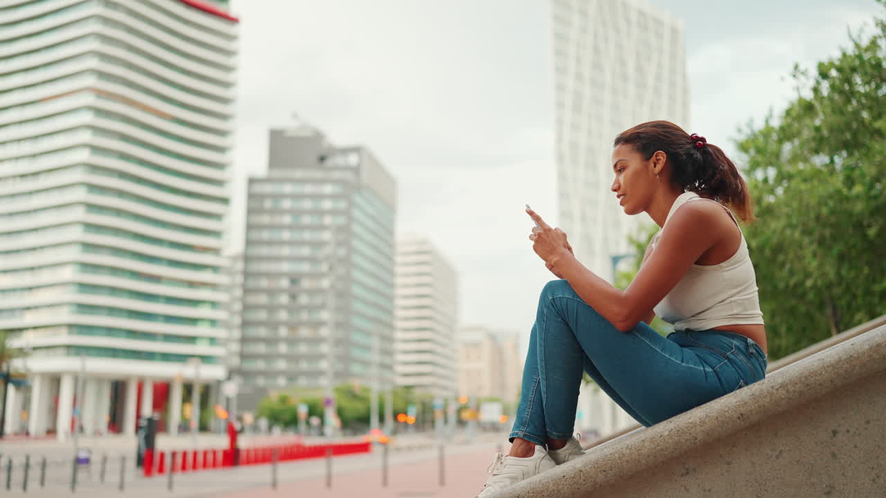 Donna seduta in città con il cellulare