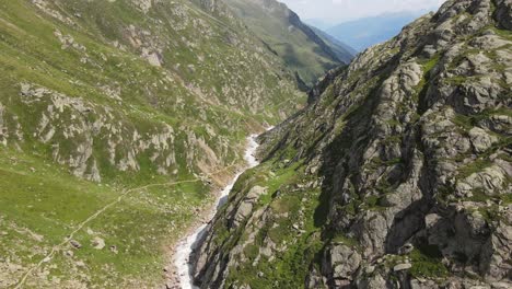 wide angle drone video of the beautiful mountains in northern italy with a giant waterfall and river