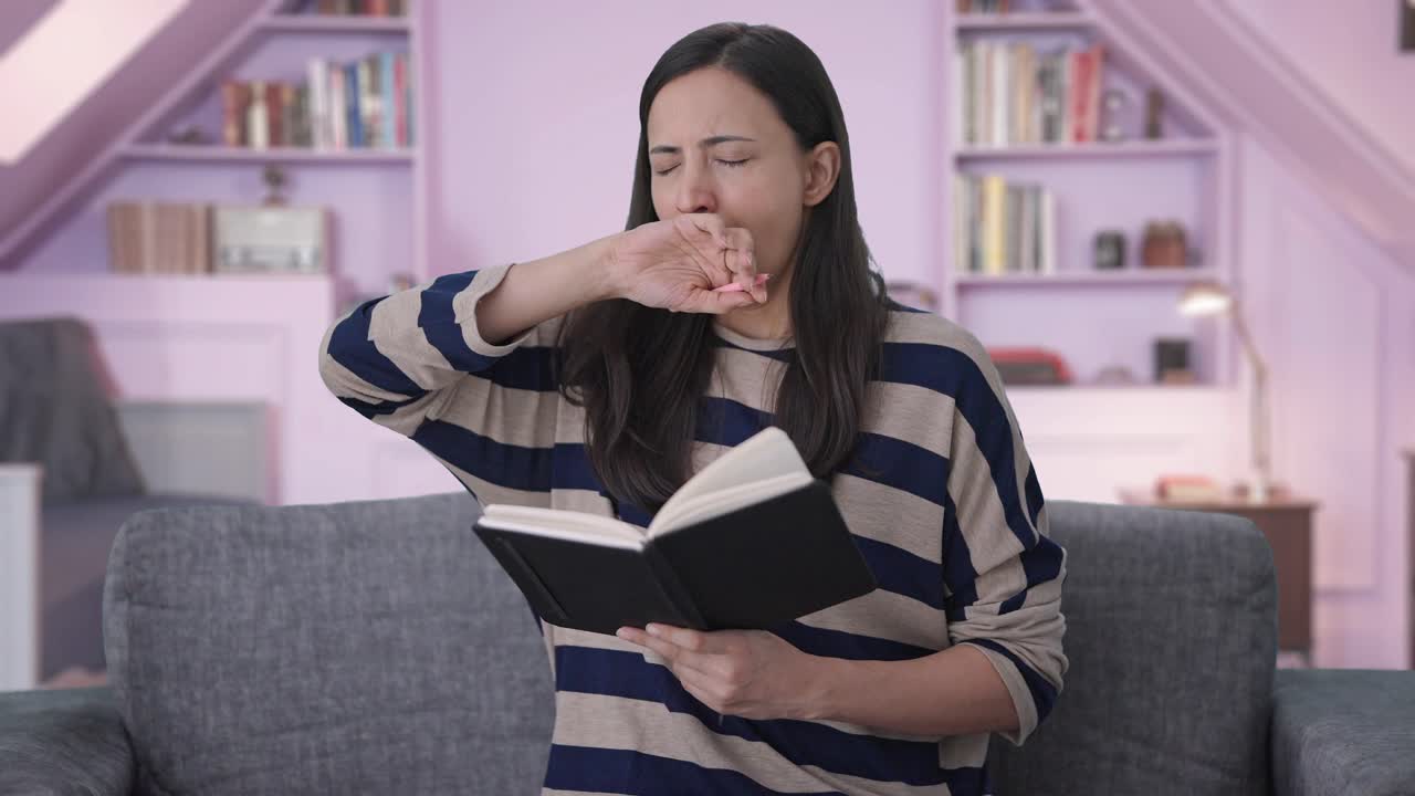 지친 인도 소녀가 책을 쓰고 있습니다.