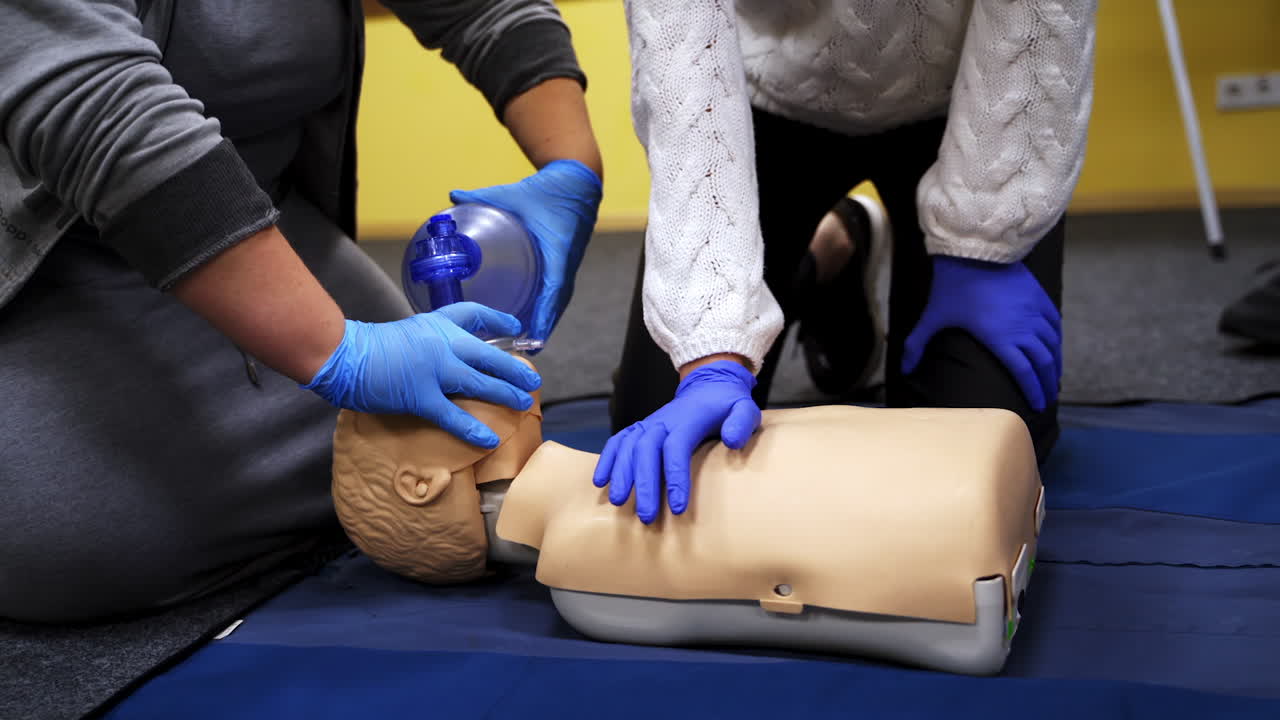 First aid reanimation. Women in safety gloves trying resuscitation technique on dummy. Cardiopulmonary training on a mannequin. Healthcare and medical concept.