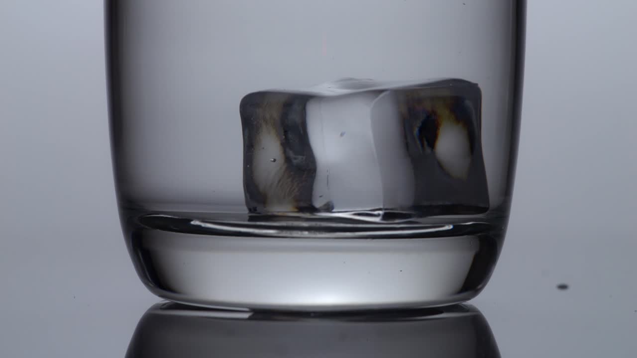 cubo de hielo en un vaso de agua