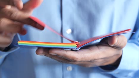 person holding a rainbow colored notebook