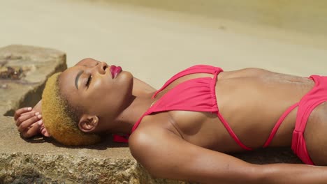 En-Una-Playa-Caribeña-De-Arena-Blanca,-Una-Chica-Negra-Con-Un-Bikini-Rojo-Abraza-Las-Vibraciones-Tropicales