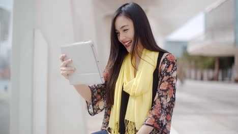 Excited-woman-waving-at-her-tablet-computer