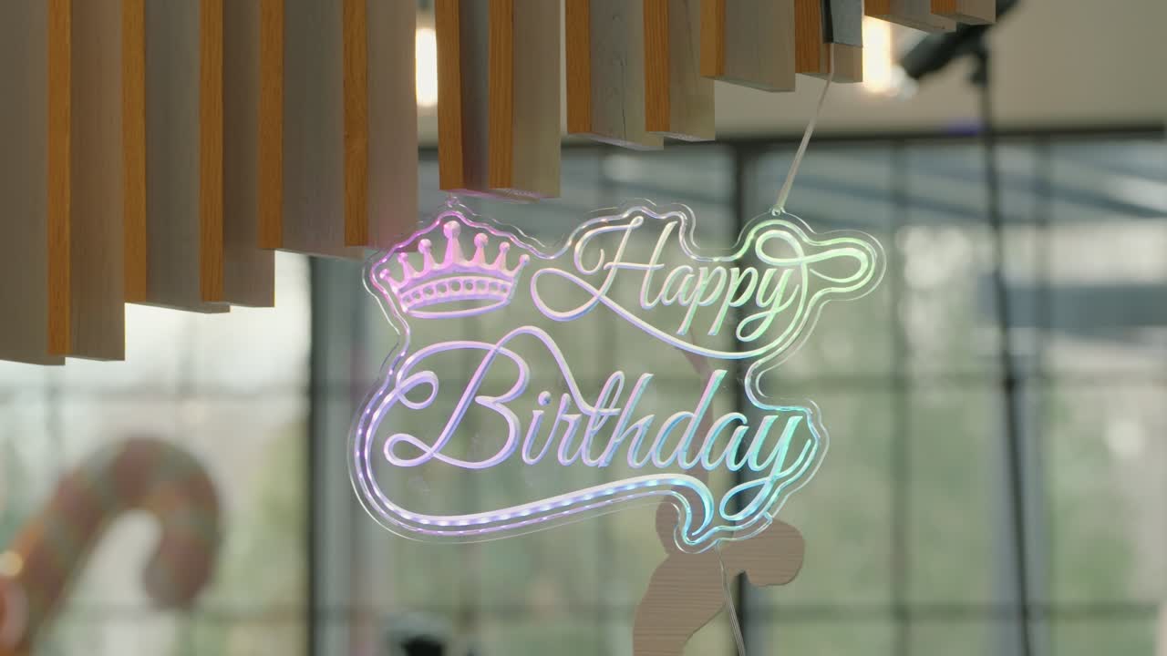 Zooming out of Glowing “Happy Birthday” Sign with Crown Accent for a Festive Celebration