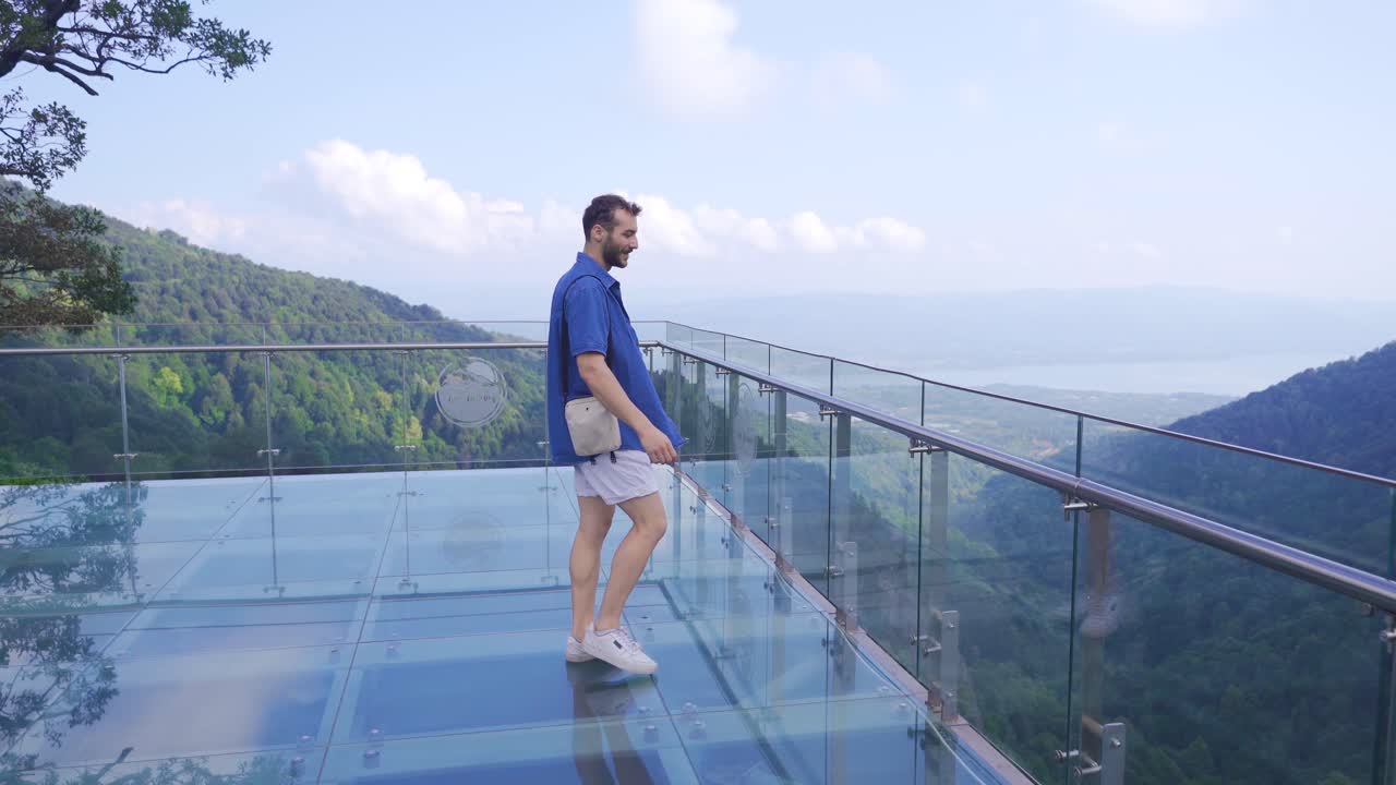 el hombre caminando por el valle observa el valle desde la terraza de vidrio.