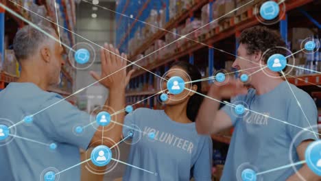 Animation-of-network-of-connections-with-icons-over-diverse-workers-in-warehouse