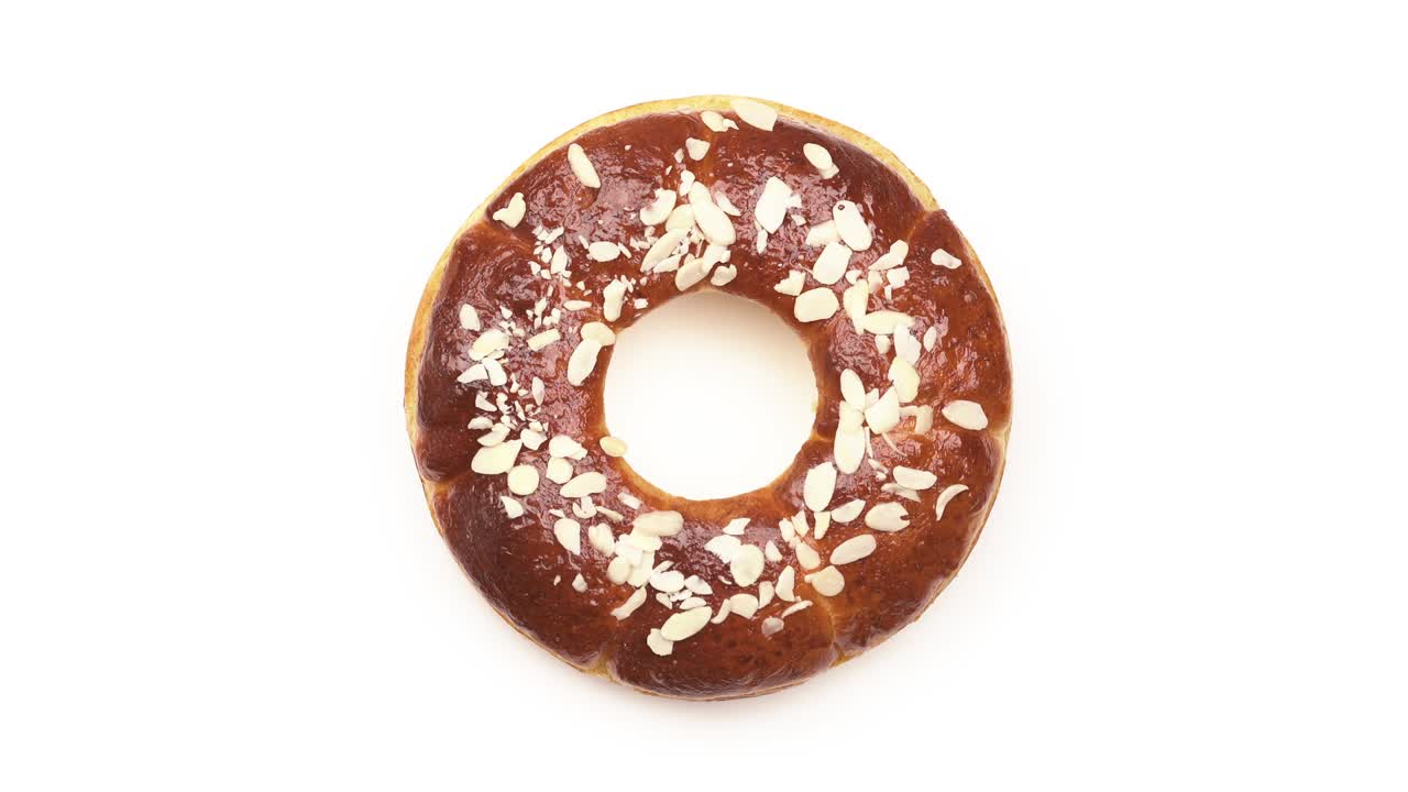 saborosa rosquilla de chocolate con patatas fritas de almendra en la mesa giratoria. aislada sobre un fondo blanco. vista superior. producto de pastelería dulce