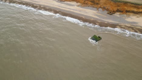 Aerial-view-of-continuous-waves-hitting-the-shore-of-Kessingland-Beach-in-Suffolk,-England