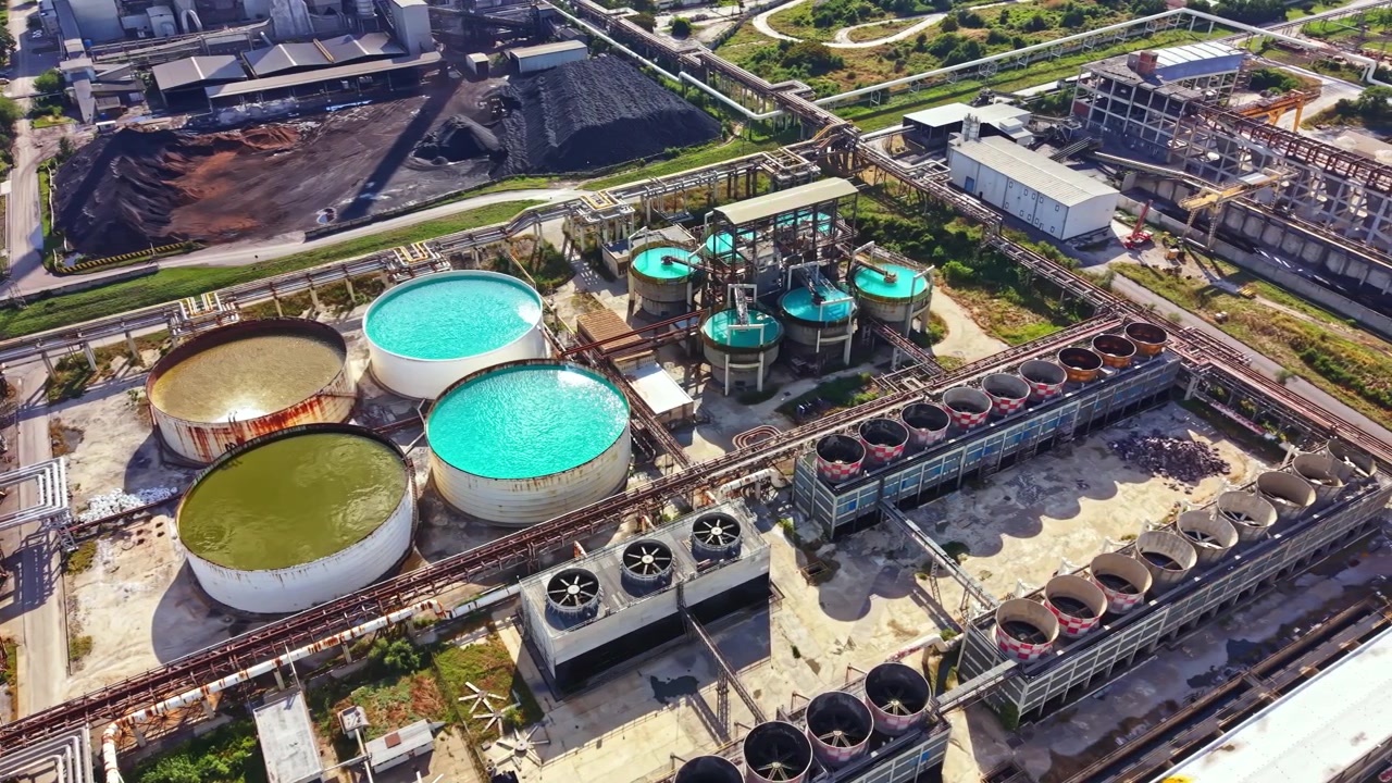 Large industrial facility with various storage tanks and processing units during daylight hours