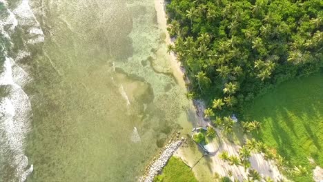 A-lush-miami-coastline-with-waves-gently-crashing,-sunny-day,-aerial-view,-in-the-United-States-of-America