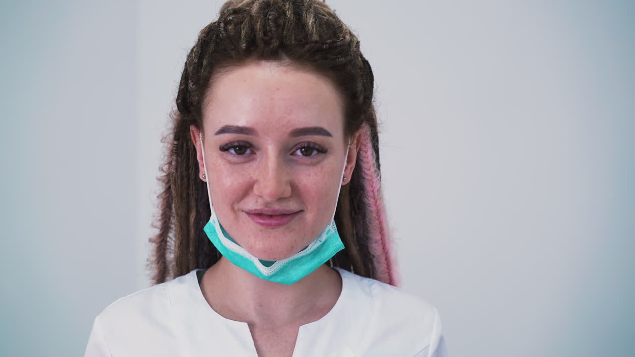 dermatólogo con rastas se quita las gafas en la clínica