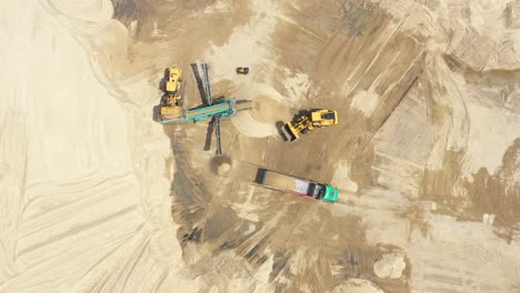 Aerial-view-loading-bulldozer-in-open-air-quarry