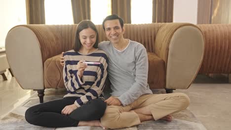 happy indian couple checking pregnancy kit