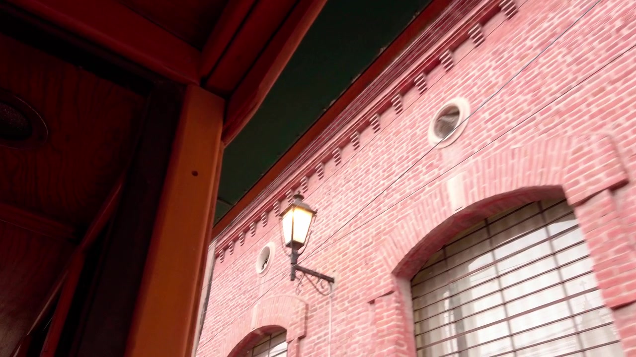 Vista en ángulo bajo de un edificio histórico de ladrillo en Cuernavaca, Morelos, filmado desde un vehículo en movimiento, mostrando arquitectura colonial y una fachada histórica.
