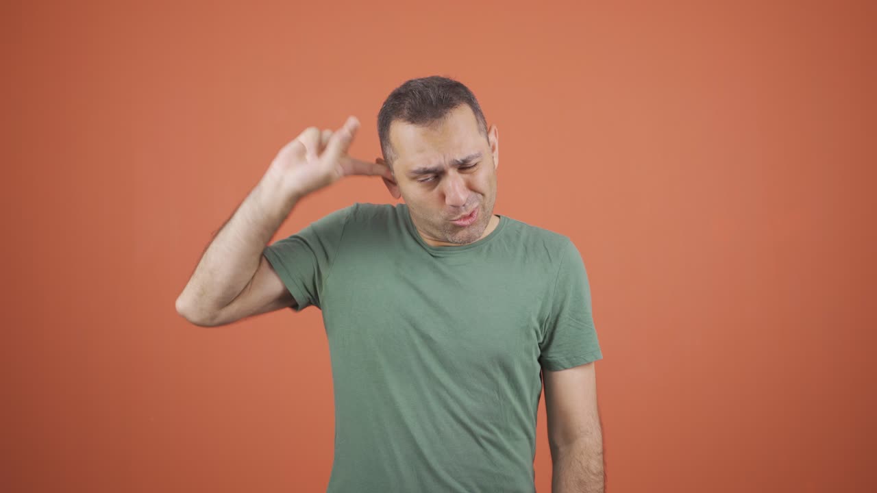 un hombre de negocios rascándose la oreja.