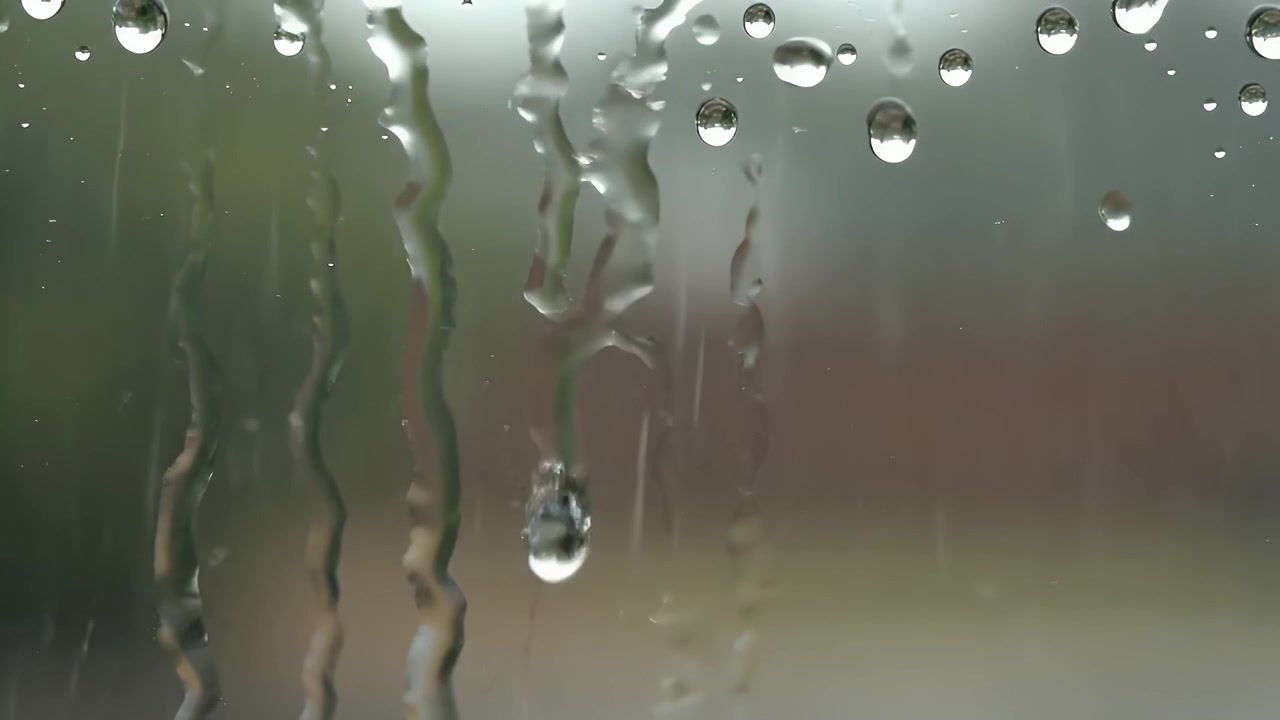 Raindrops Running Down a Windowpane During a Storm