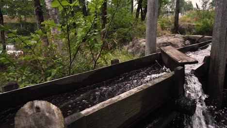 water going through old wooden river mill in slow motion bypassed