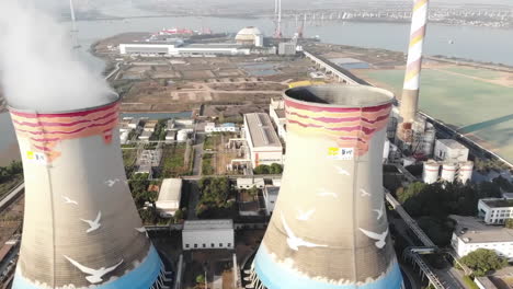 aerial view of a large power plant with painted cooling towers