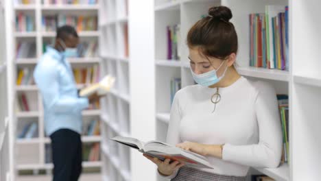 woman reading a book in a library during covid-19