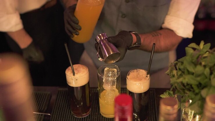 Barman che lavora nel servizio di mixology servendo birre e cocktail