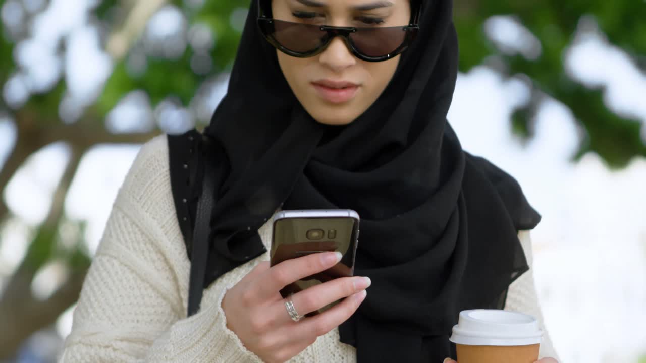 Woman in hijab using mobile phone 4k