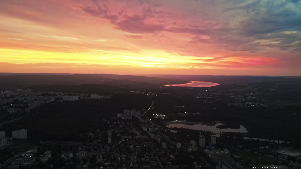 Aerial drone view of Chisinau, Moldova at sunset. Lakes, nightlights, roads with cars, buildings