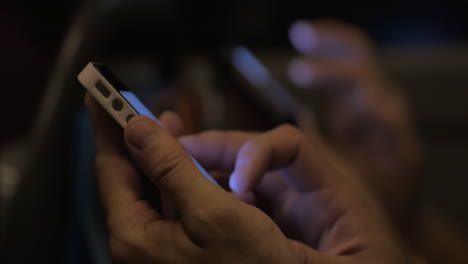 man using mobile phone in the bus at night