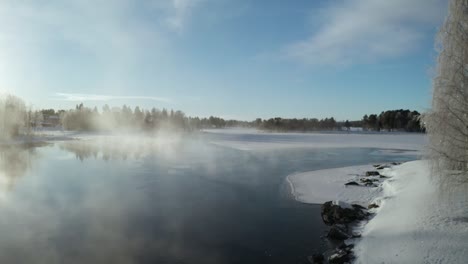 drone shot flying over frozen water and through mist in northern sweden