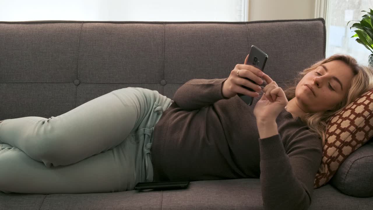 Young blonde woman texting on her cellphone