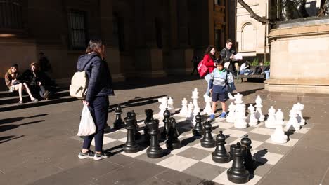 people playing giant chess outside library